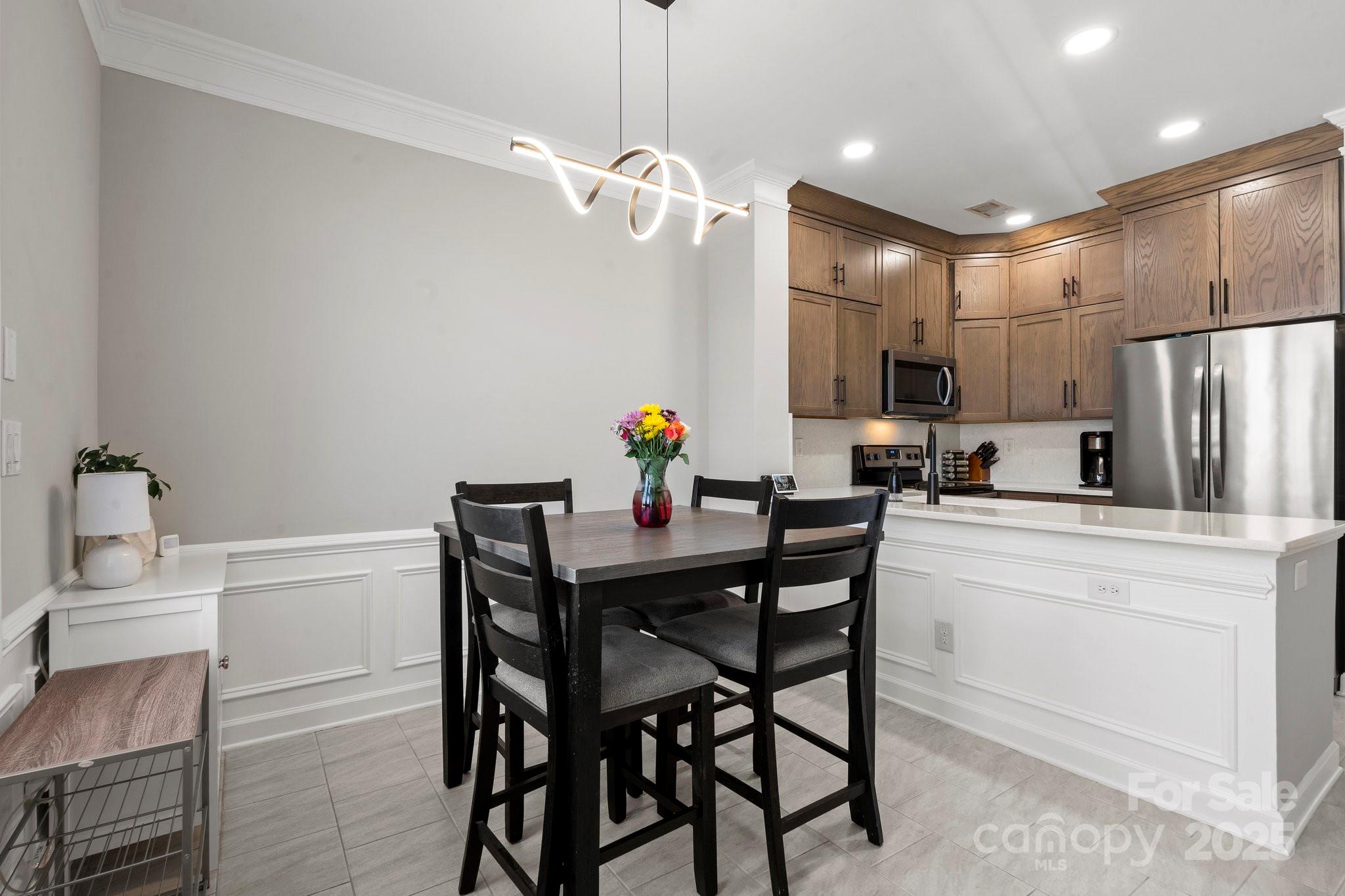 164 Singleton Road Mooresville, NC 28117 - Photo 14 of 36 a kitchen with a dining table cabinets appliances and a counter top space