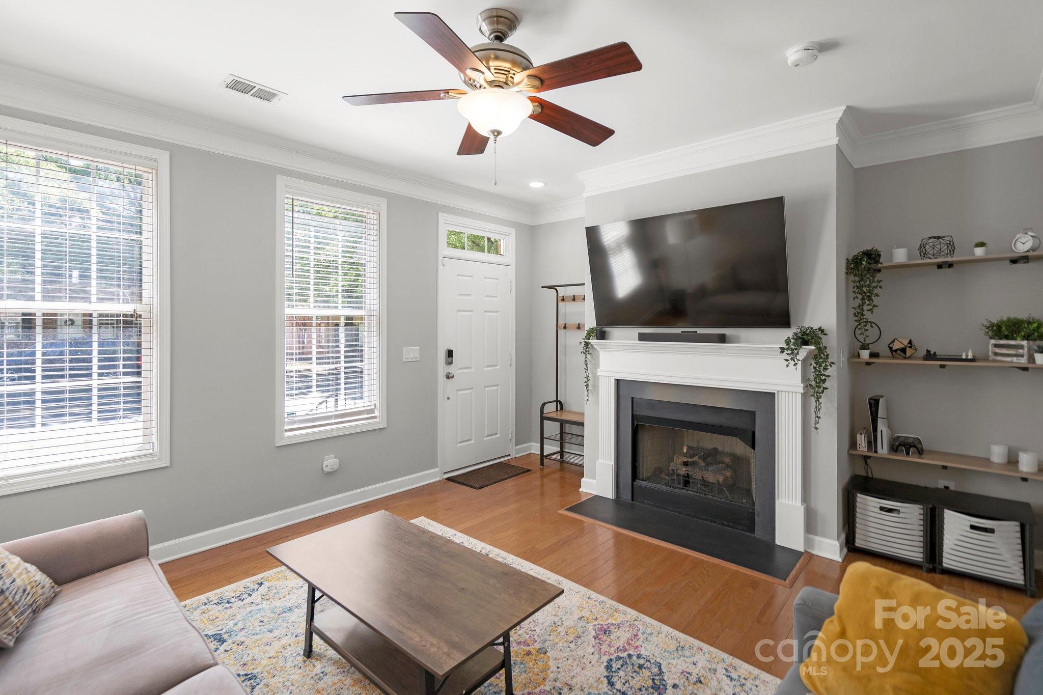 164 Singleton Road Mooresville, NC 28117 - Photo 7 of 36 a living room with furniture a flat screen tv and a fireplace