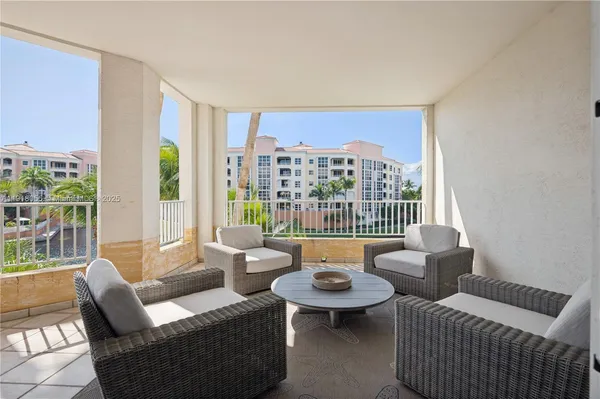 a view of a balcony with table and chairs and potted plants