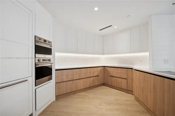 a kitchen with cabinets and chairs