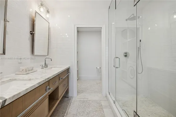 a spacious bathroom with a shower sink and mirror