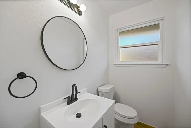 a bathroom with a sink a toilet and a mirror