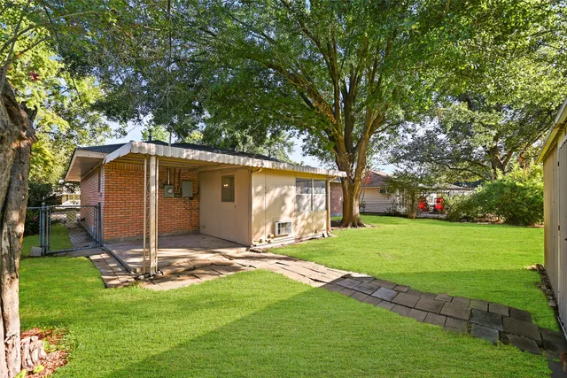 a view of a house with backyard and a tree