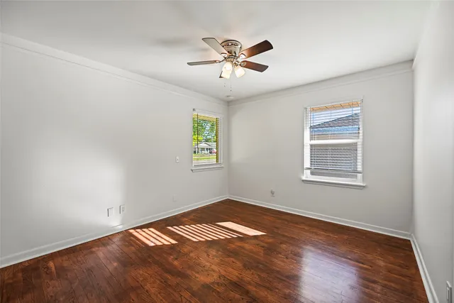 a view of empty room with wooden floor