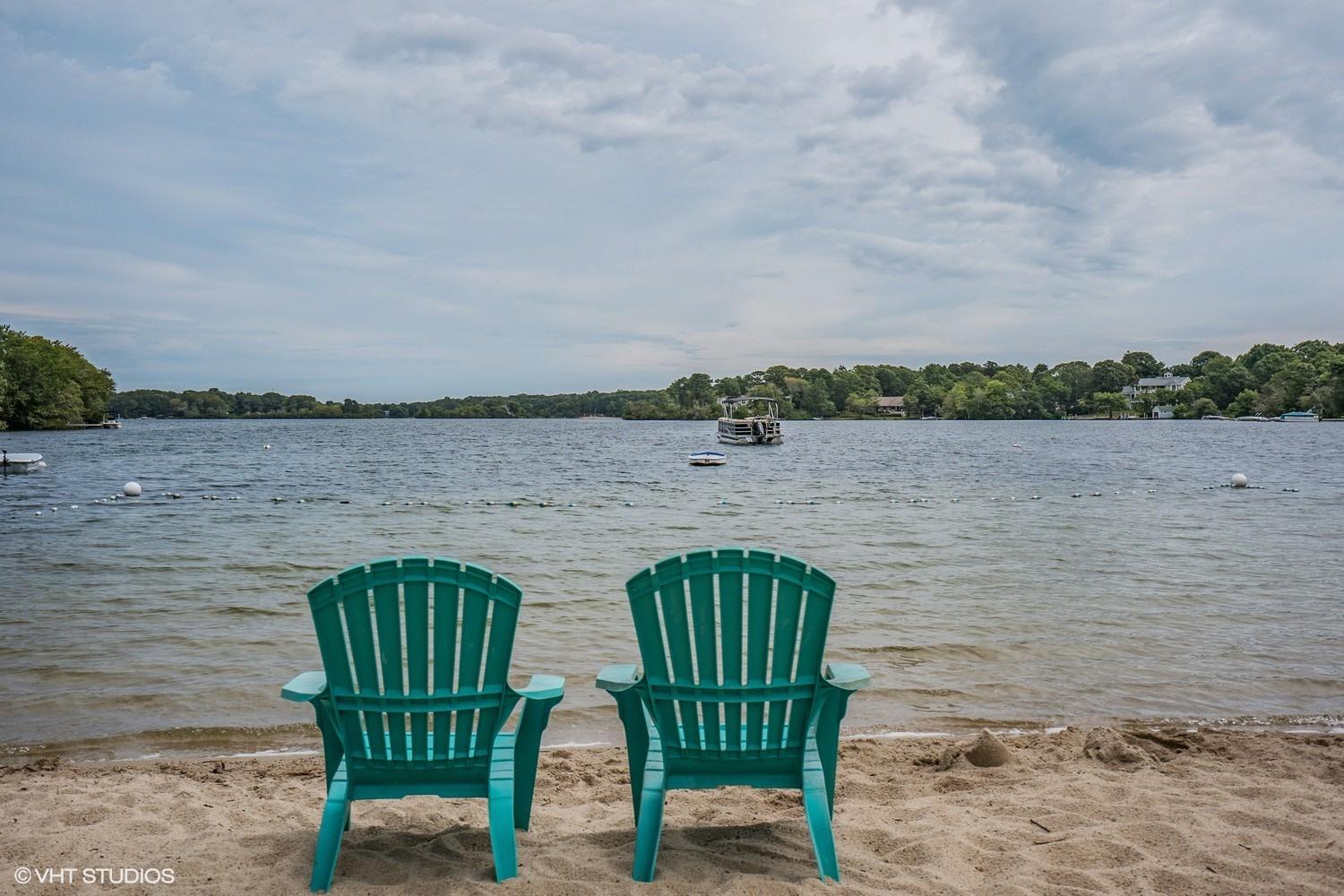 14 Nathan Road Centerville, MA 02632 - Photo 15 of 16 a view of a lake with lawn chairs and a table