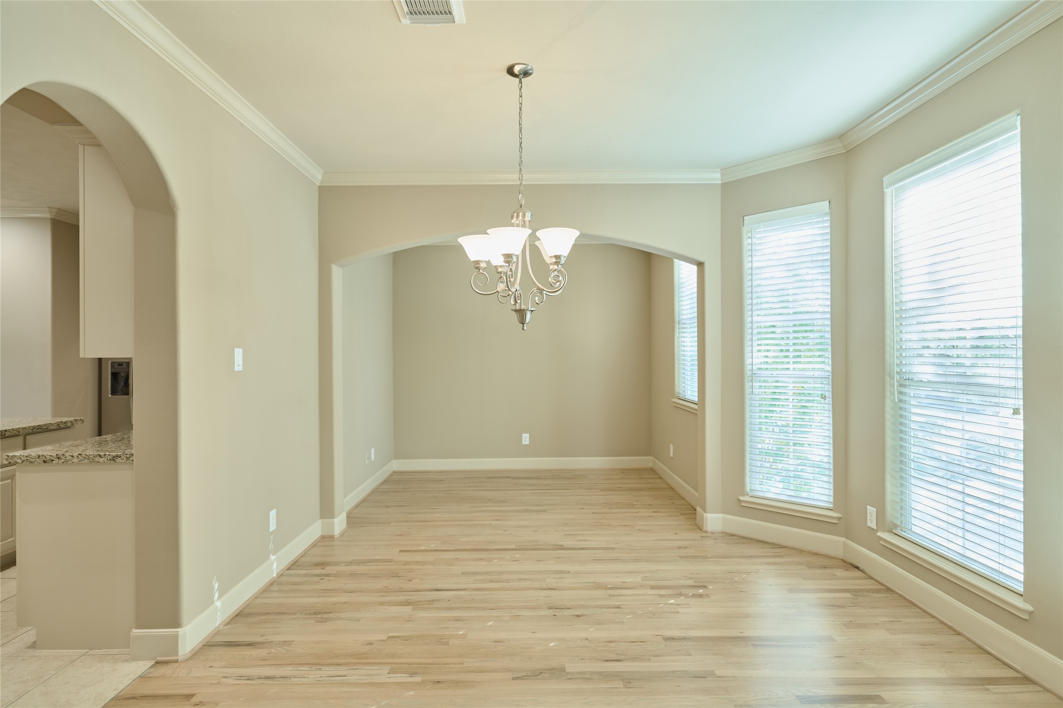5612 Lacy Street Houston, TX 77007 - Photo 5 of 22 a view of a hallway with wooden floor and a chandelier