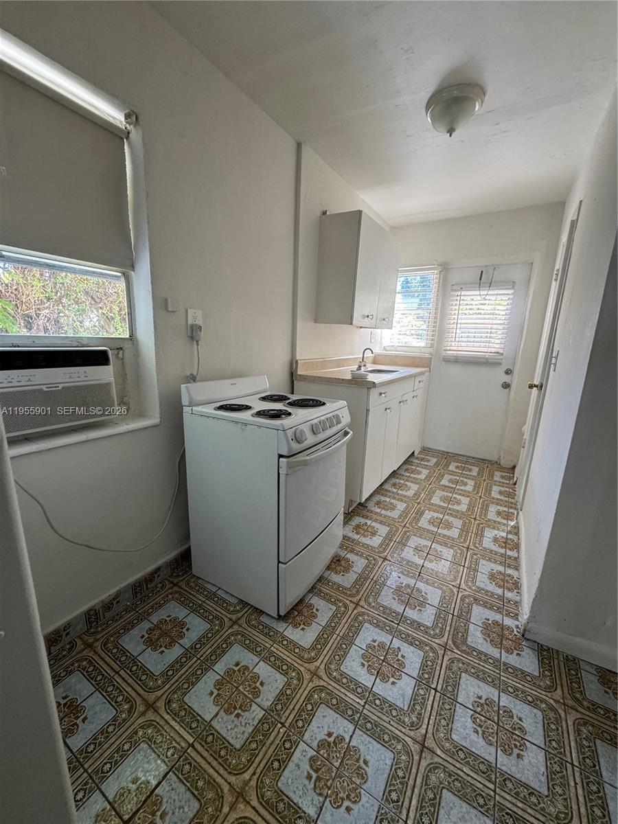 3690 Southwest 14th Street, Unit 1 Miami, FL 33145 - Photo 13 of 13 a kitchen with a stove and white cabinets