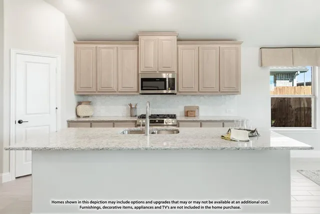a kitchen with granite countertop a stove a sink and a refrigerator