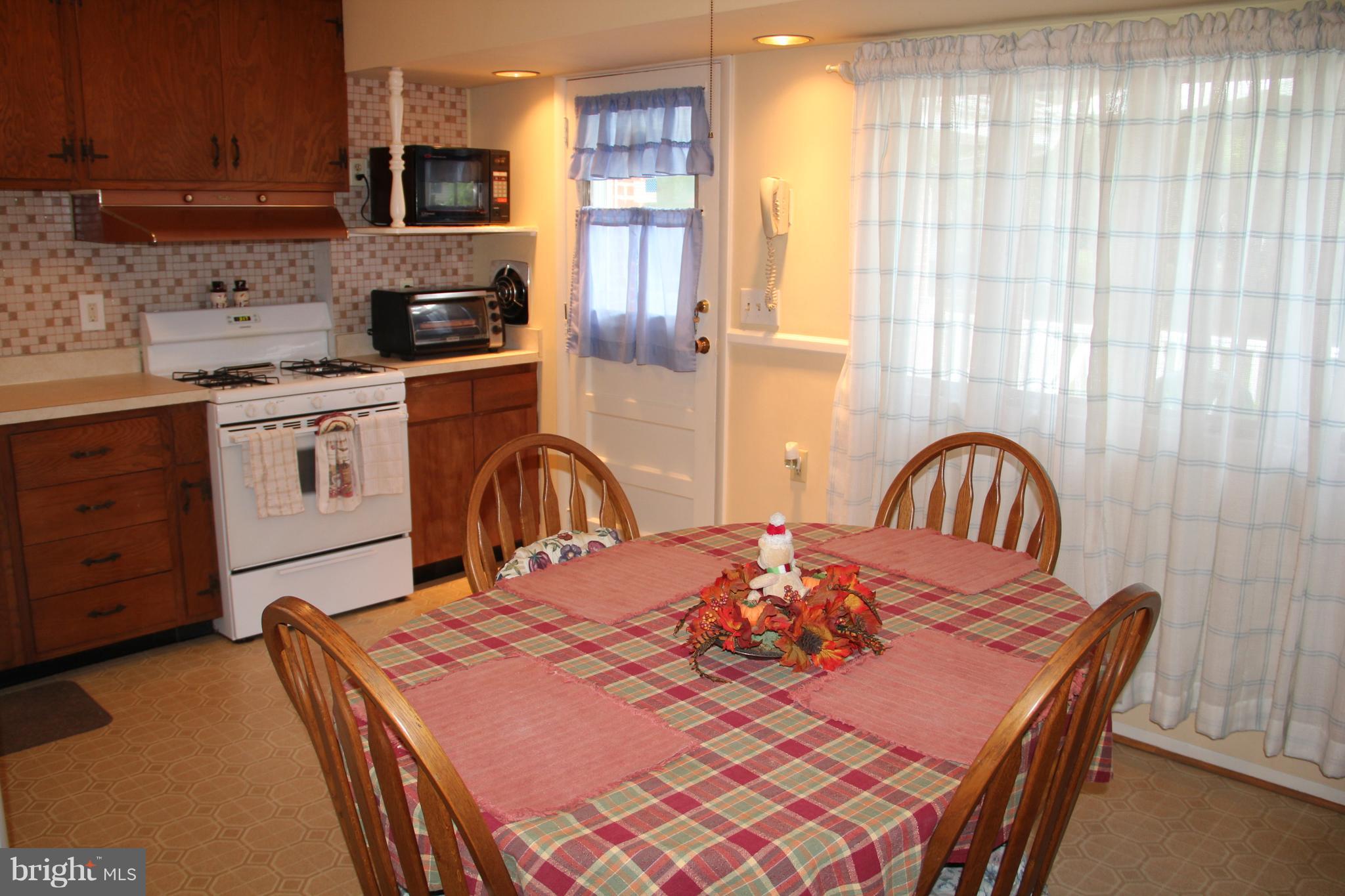 9511 Holiday Manor Road Baltimore, MD 21236 - Photo 8 of 29 a kitchen with stainless steel appliances granite countertop a stove a sink a dining table and chairs