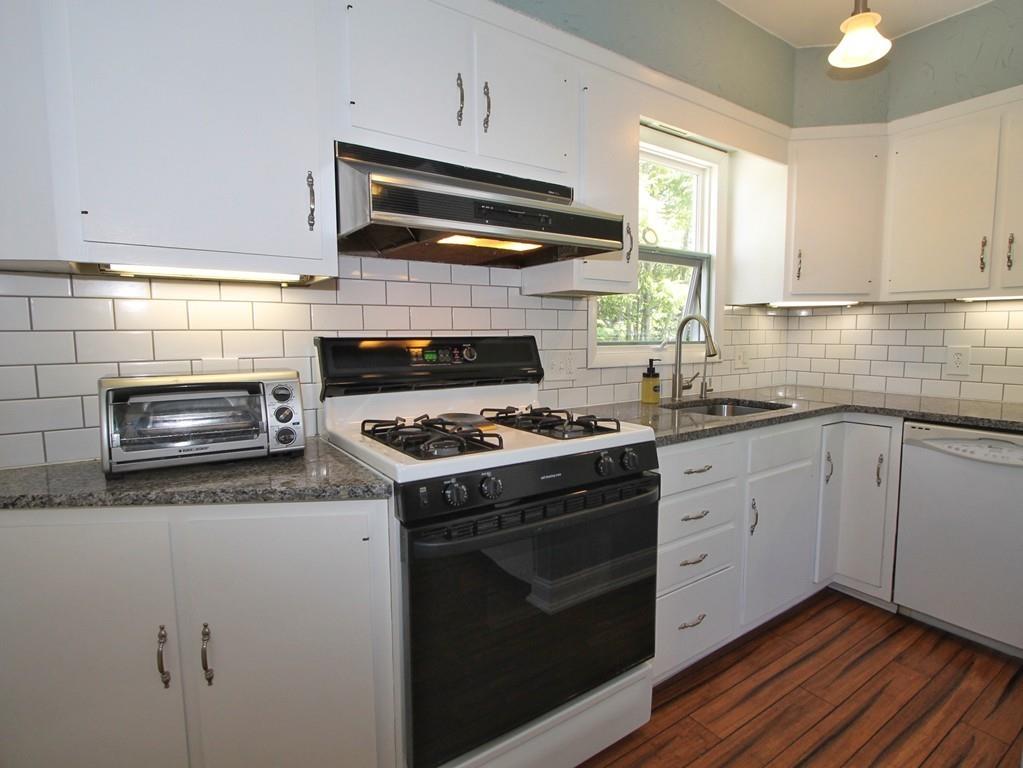 65 King Philip Road Worcester, MA 01606 - Photo 5 of 15 a kitchen with granite countertop cabinets stainless steel appliances and wooden cabinets