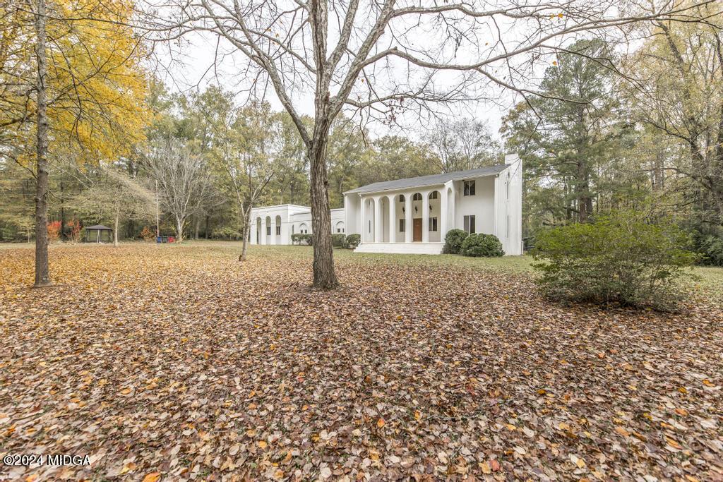 6909 Forsyth Road Macon, GA 31210 - Photo 3 of 53 a front view of a house with a yard and trees