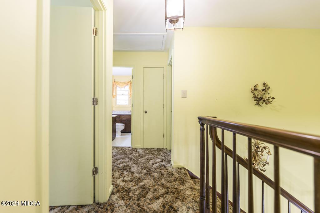 6909 Forsyth Road Macon, GA 31210 - Photo 35 of 53 a view of a hallway with wooden floor and a bathroom