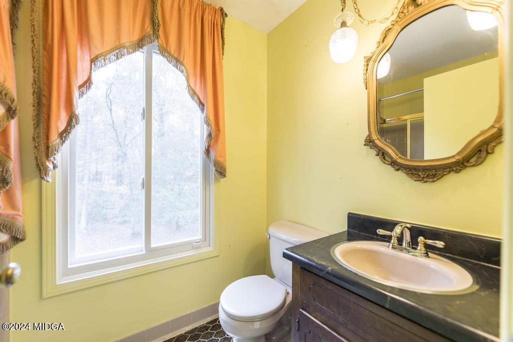 6909 Forsyth Road Macon, GA 31210 - Photo 39 of 53 a bathroom with a granite countertop sink and a mirror