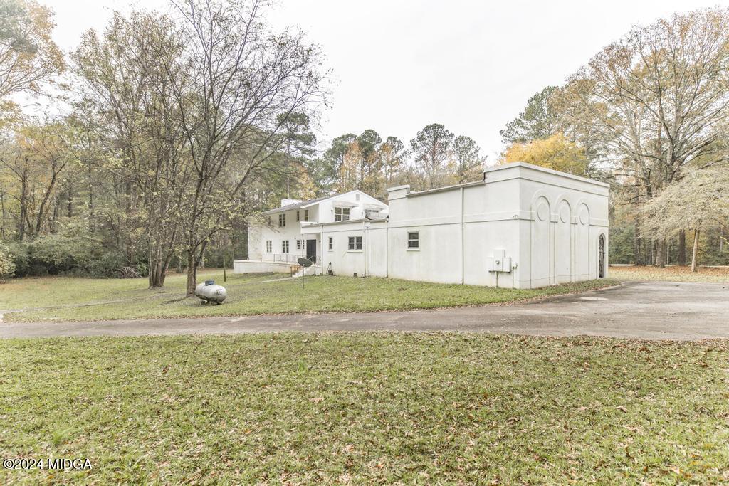 6909 Forsyth Road Macon, GA 31210 - Photo 51 of 53 a view of a white house with a yard and large trees