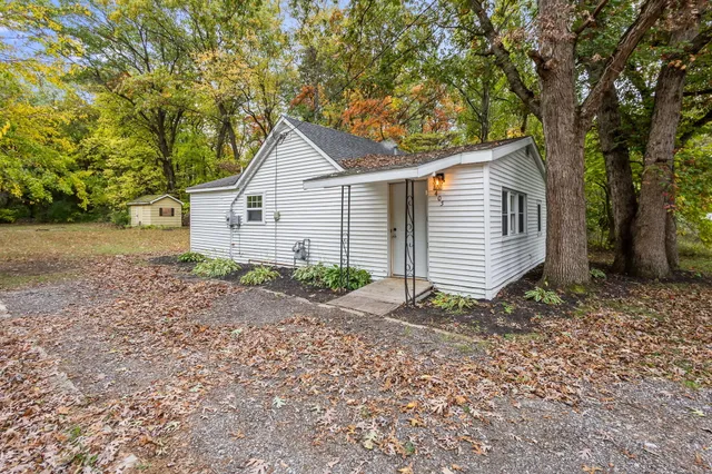 a view of a house with a yard and large tree