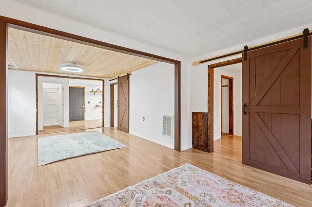 a spacious bedroom with a bed and wooden floor