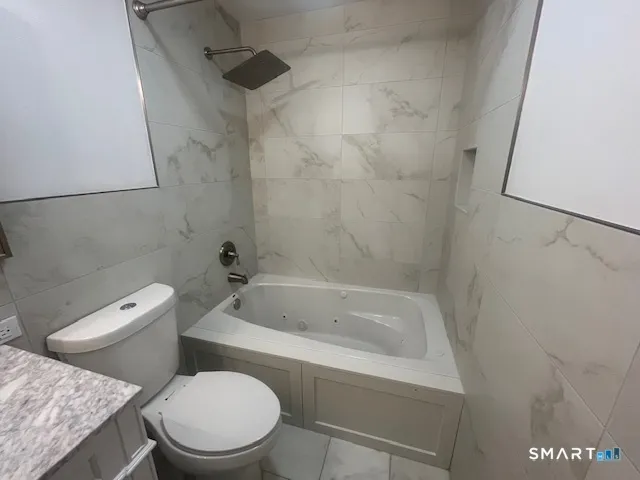 a white toilet sitting next to a bath tub