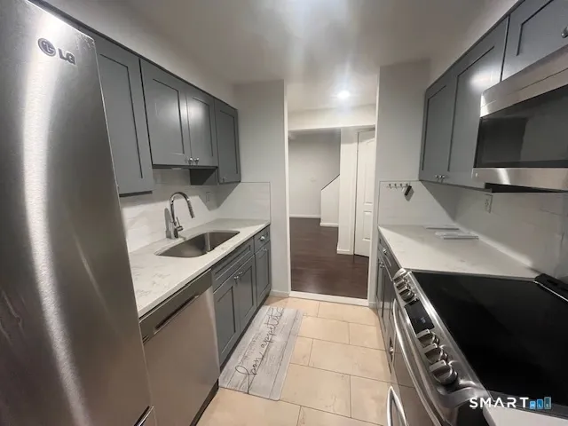 a kitchen with a sink stainless steel appliances and cabinets