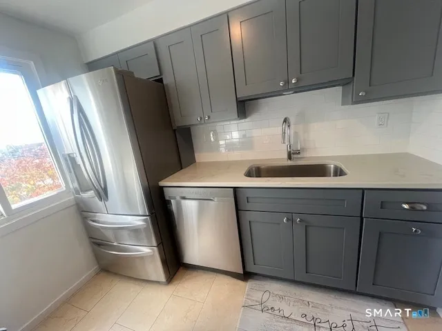 a kitchen with stainless steel appliances a refrigerator sink and cabinets
