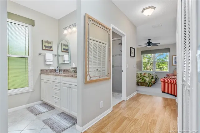 a bathroom with a granite countertop tub sink and mirror