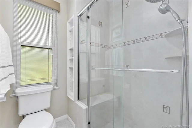 a bathroom with a toilet and a shower