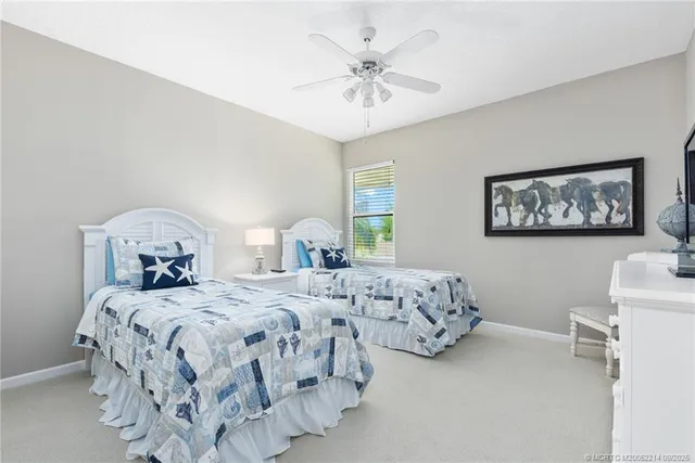 a bedroom with two beds and a chandelier