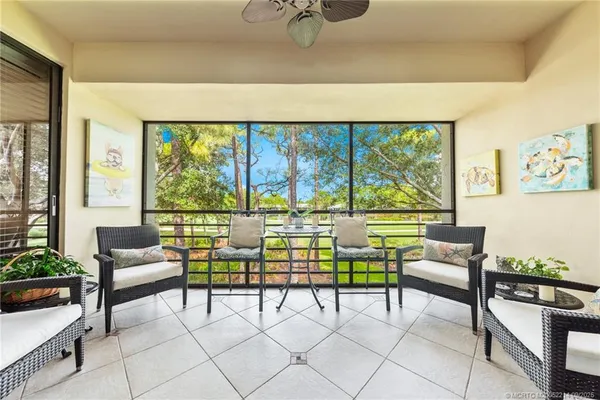 a living room with furniture and a floor to ceiling window
