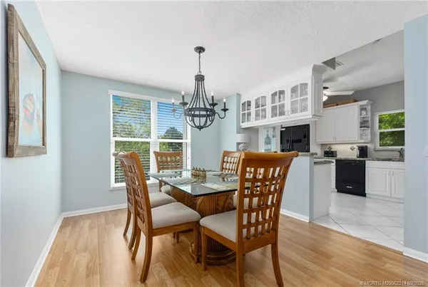 a dining room with furniture a chandelier and wooden floor