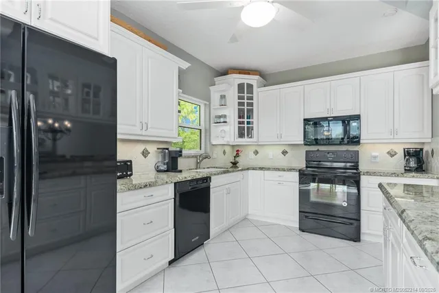 a kitchen with granite countertop white cabinets and stainless steel appliances