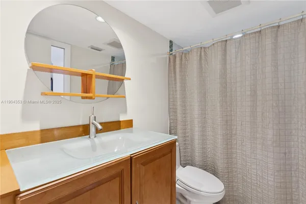 a bathroom with a sink a toilet and shower curtain