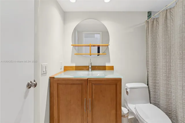 a bathroom with a toilet a sink and mirror