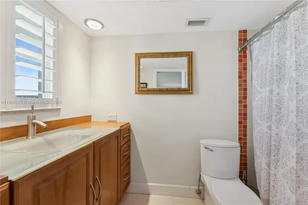a bathroom with a sink a toilet and a window