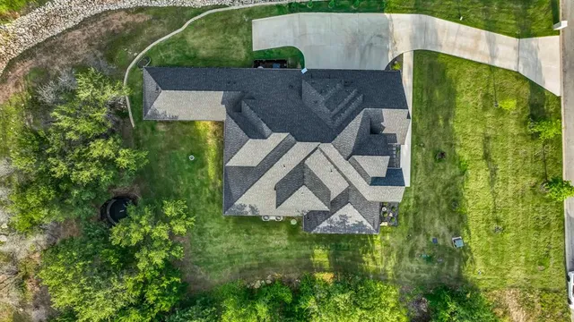 an aerial view of a house with a yard and trees