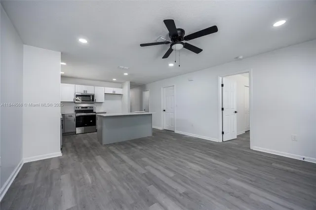 a view of kitchen with refrigerator and microwave