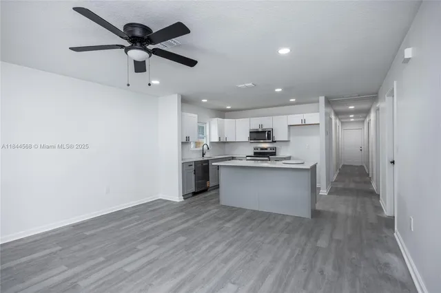 a kitchen with a refrigerator and white cabinets