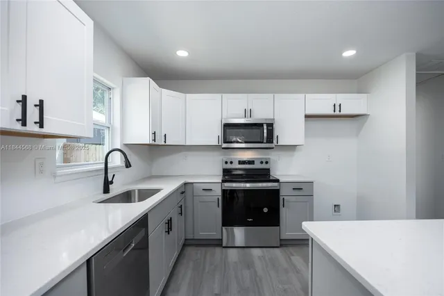 a kitchen with stainless steel appliances a sink stove and cabinets