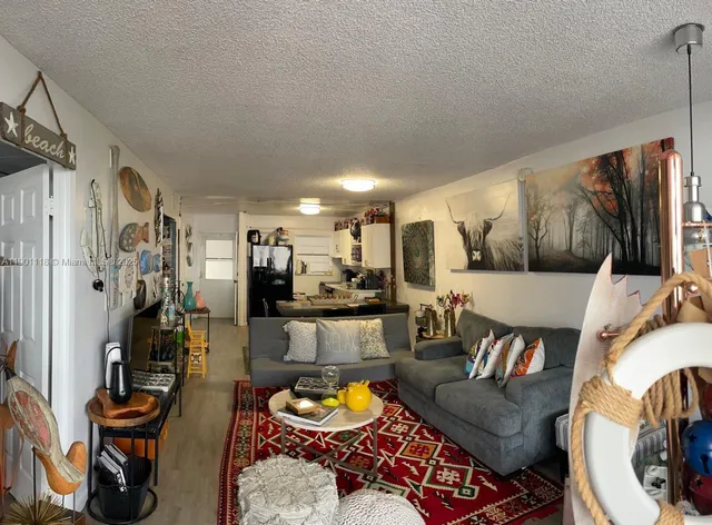 a living room with furniture kitchen view and a window