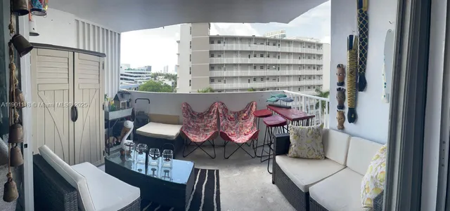 a large white kitchen with a sink a stove a washer dryer and a view of living room