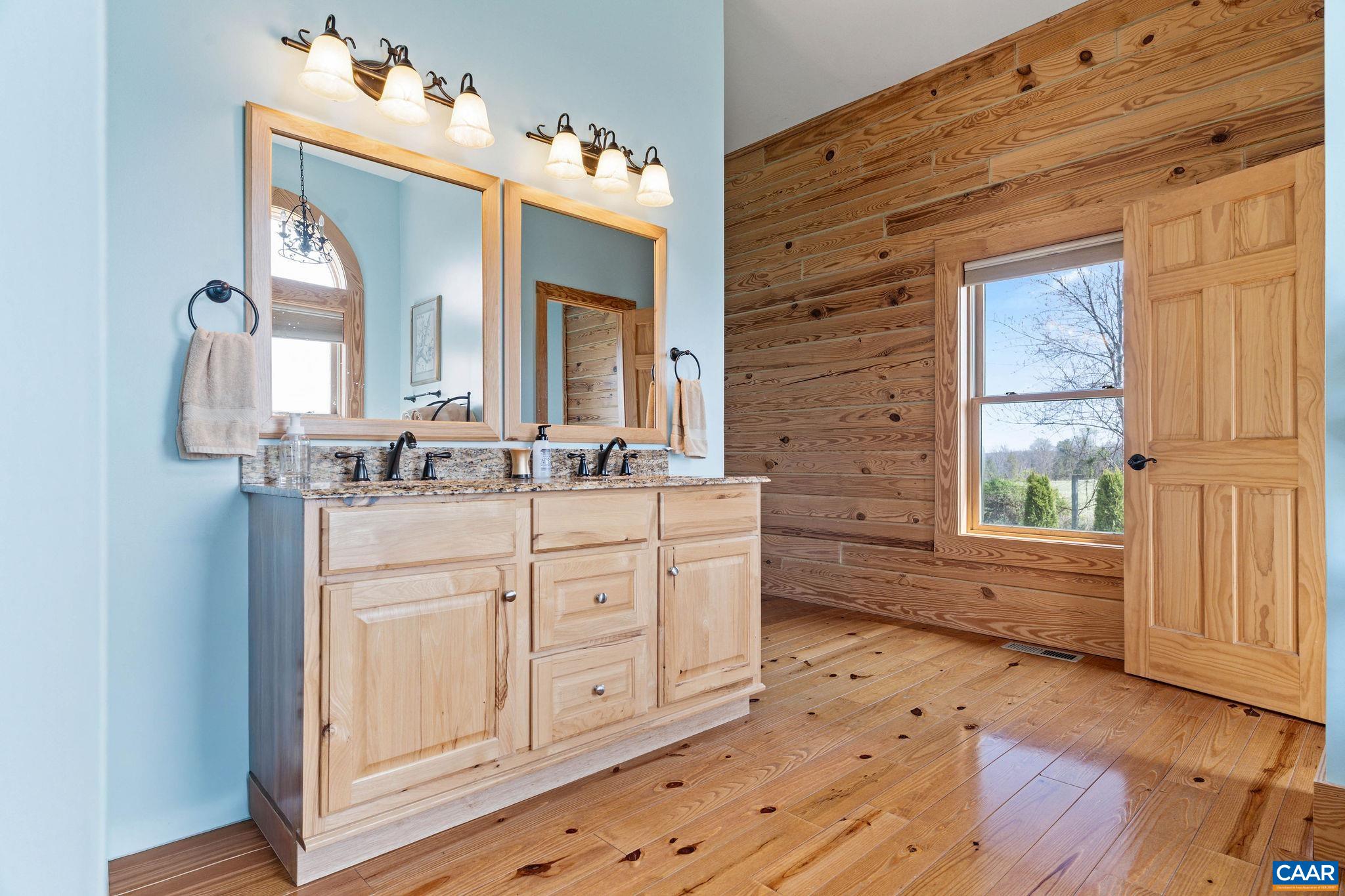 42 River Ridge Lane Stanardsville, VA 22973 - Photo 28 of 70 a bathroom with a double vanity sink a mirror and a bathtub