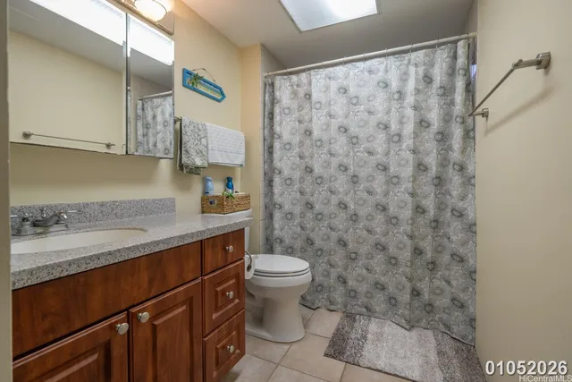 a bathroom with a granite countertop sink a toilet and a mirror