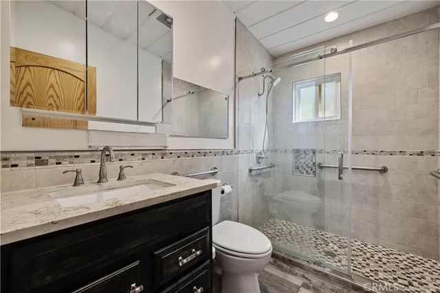 a bathroom with a sink a toilet and shower