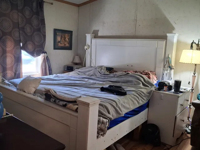 a bed sitting in a bedroom next to a lamp