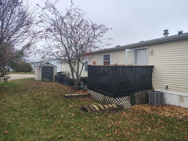 a view of a house with a large tree and wooden fence