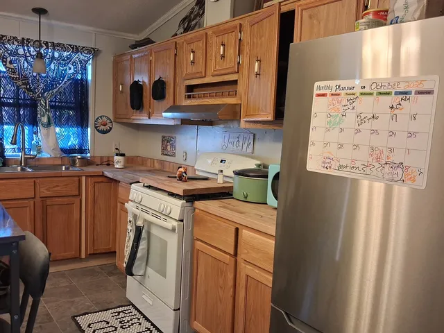 a kitchen with stainless steel appliances granite countertop a refrigerator and a stove top oven