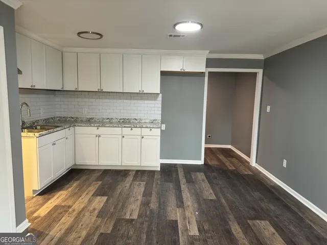 a kitchen with wooden floors and white appliances