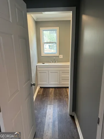 a view of a hallway with wooden floor and a cabinet