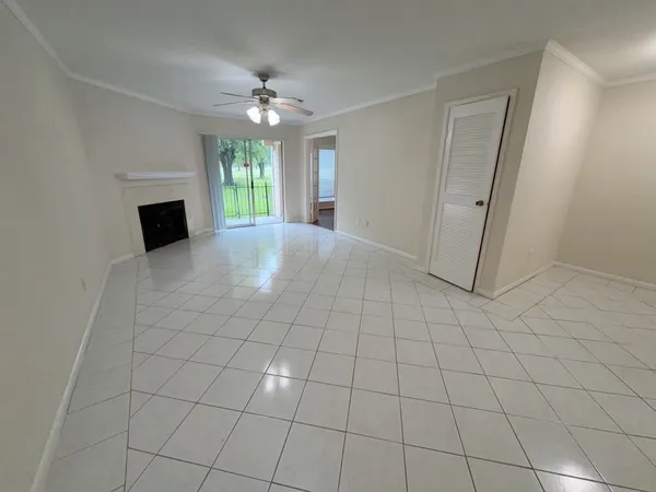 en empty room with windows and fireplace