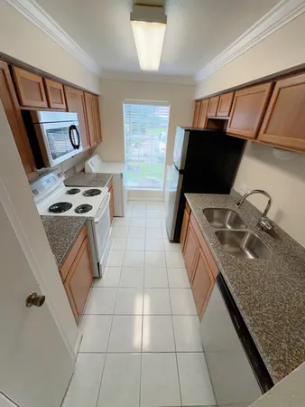 a kitchen with granite countertop a stove and a sink