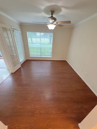 an empty room with wooden floor and windows