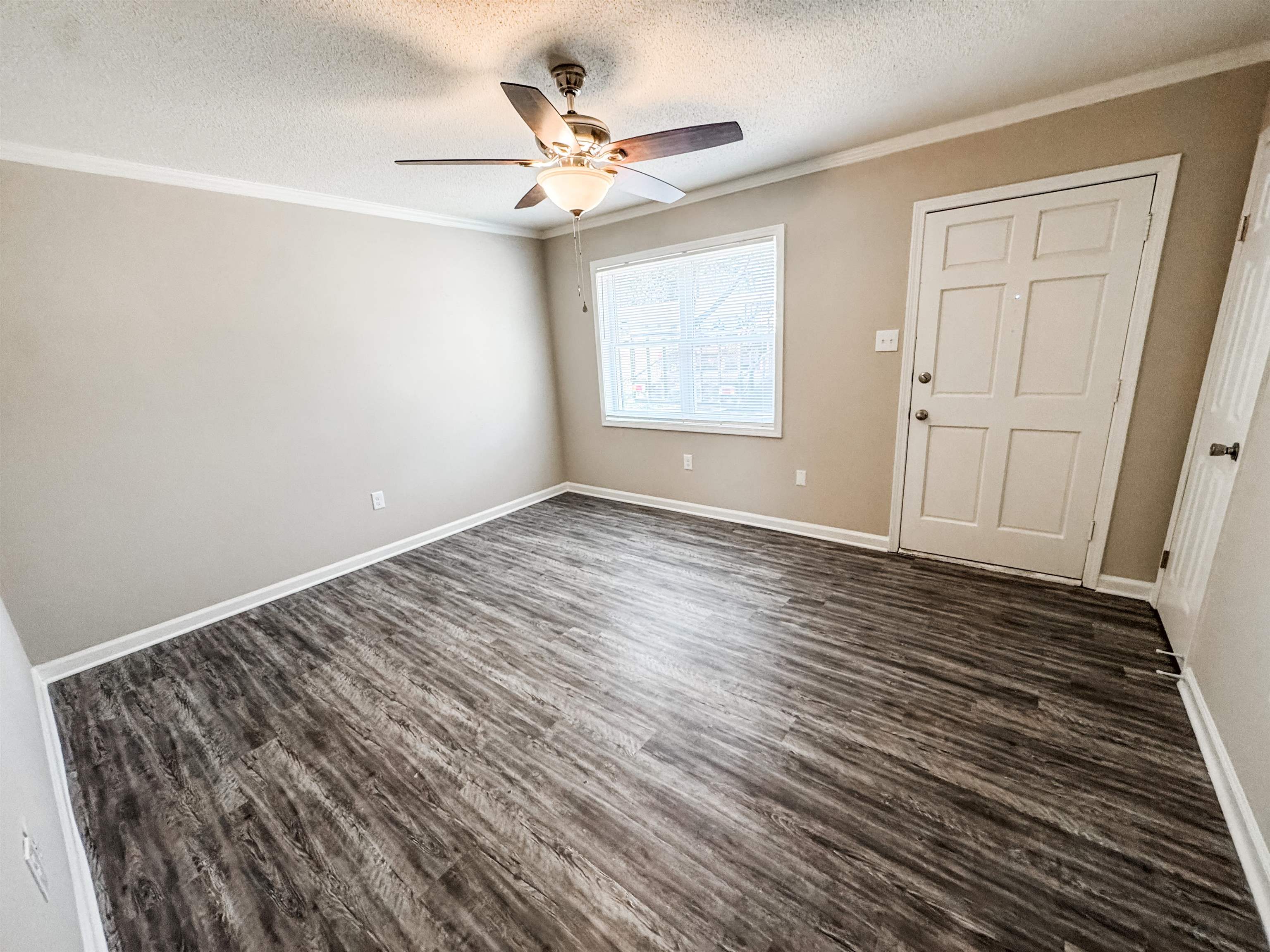 964 Greencliff Road Collierville, TN 38017 - Photo 2 of 7 Empty room featuring a textured ceiling, dark wood finished floors, crown molding, and ceiling fan